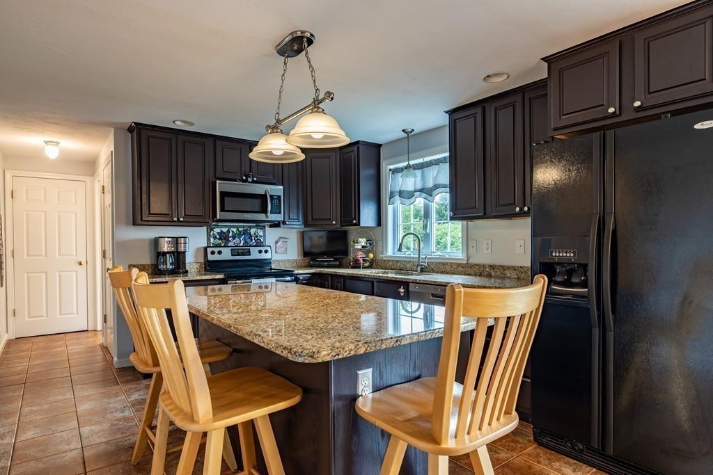 6 Carley Circle Rutland, MA 01543 - Photo 7 of 39 a kitchen with stainless steel appliances granite countertop a sink a stove a dining table and chairs