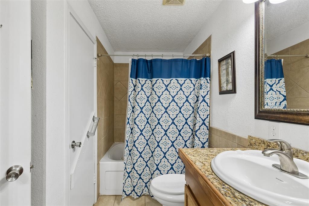 1317 Trinity View Street Irving, TX 75060 - Photo 25 of 31 a bathroom with a sink a toilet and shower curtain