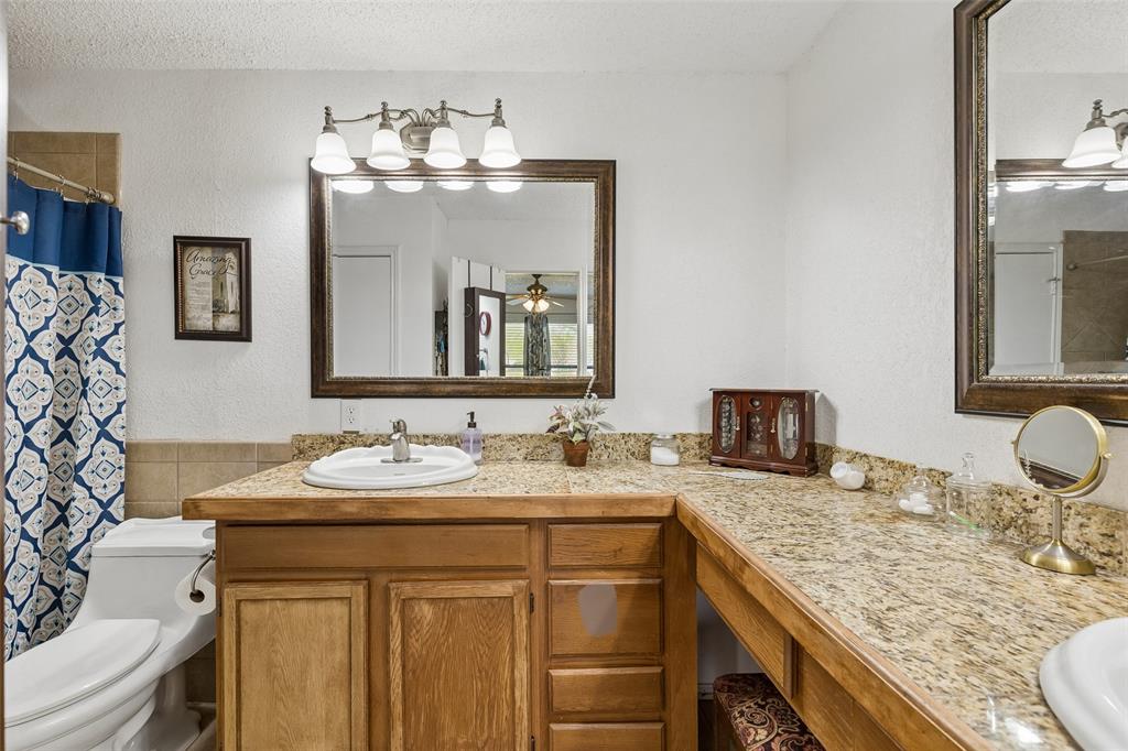 1317 Trinity View Street Irving, TX 75060 - Photo 26 of 31 a bathroom with a granite countertop sink a large mirror and vanity