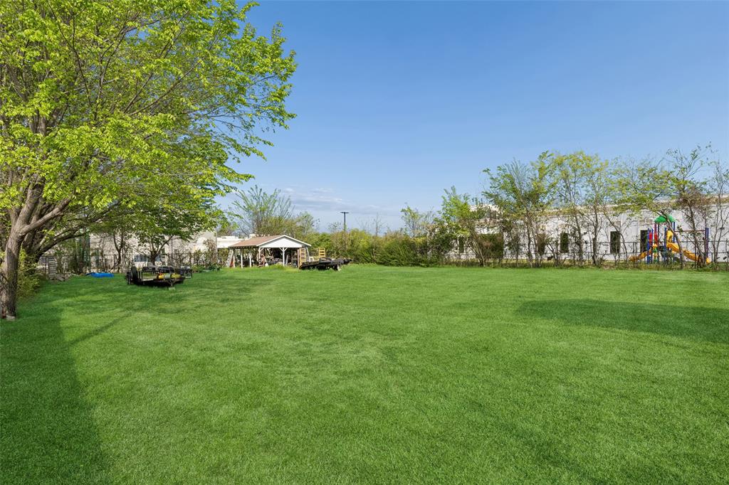 1317 Trinity View Street Irving, TX 75060 - Photo 29 of 31 a white house with a big yard and large trees