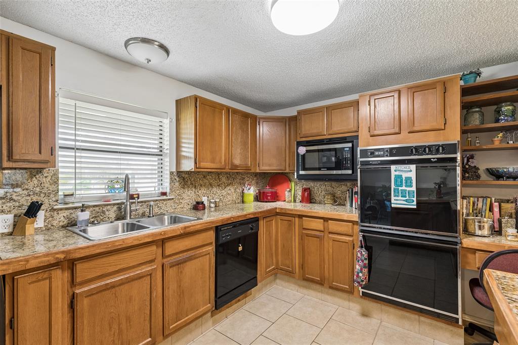 1317 Trinity View Street Irving, TX 75060 - Photo 6 of 31 a kitchen with stainless steel appliances granite countertop a sink and stove top oven