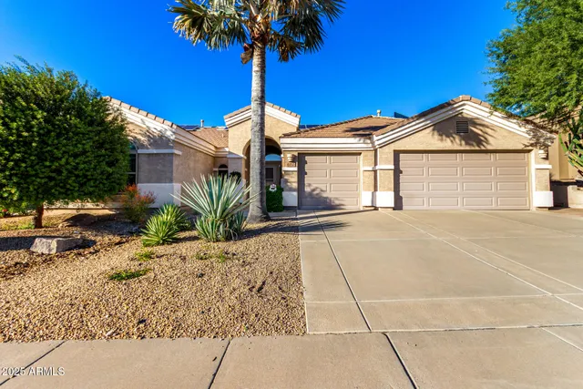 a front view of a house with a garden and trees