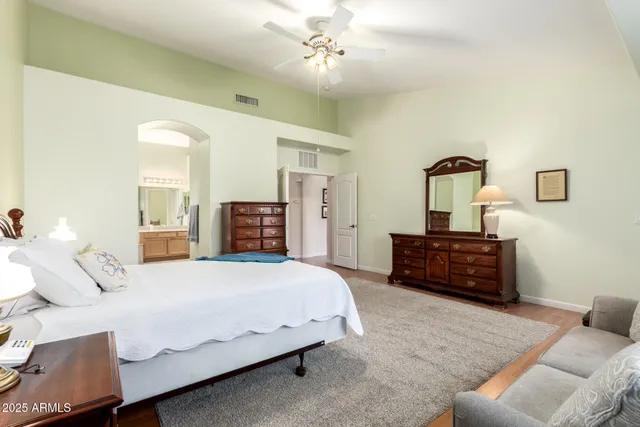 a bedroom with a bed and dresser with mirror