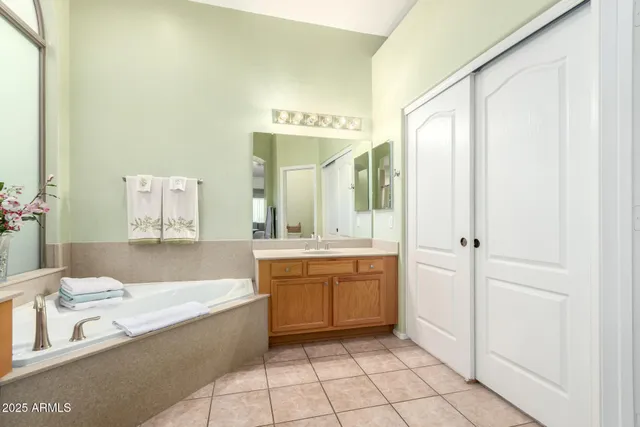 a spacious bathroom with a tub sink and mirror