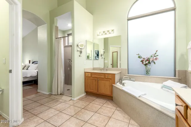a spacious bathroom with a tub sink and mirror