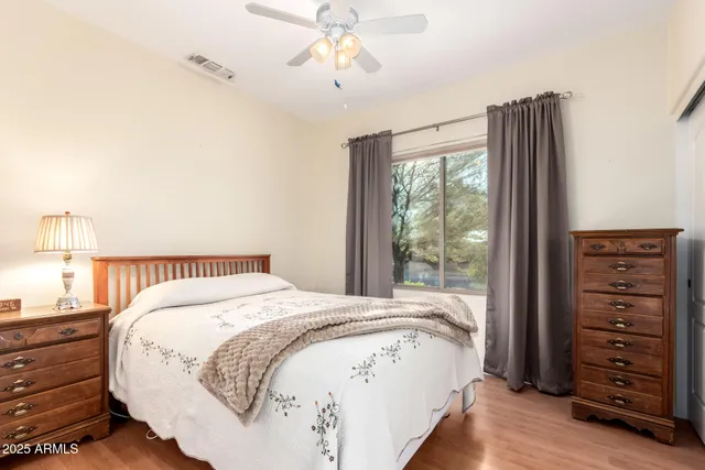 a spacious bedroom with a bed and a dresser