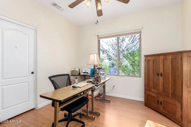 a view of a workspace with furniture and a window
