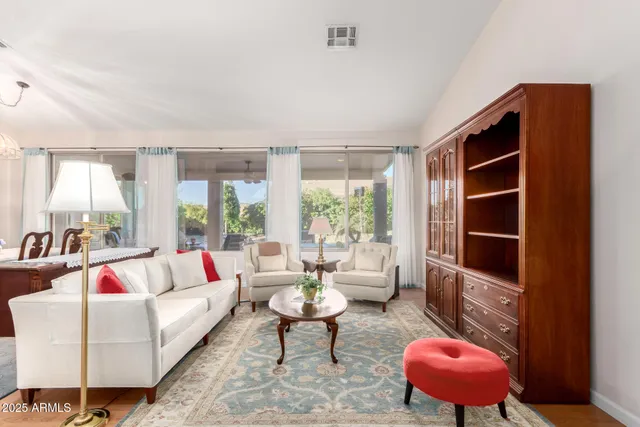 a living room with furniture a rug and a large window