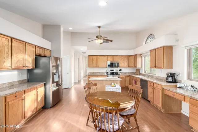 a large kitchen with kitchen island a large counter top space a sink stainless steel appliances and cabinets