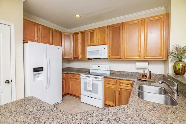 a kitchen with stainless steel appliances granite countertop a refrigerator sink and stove