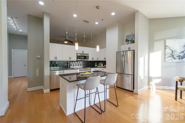 a kitchen with stainless steel appliances a refrigerator a stove a sink dishwasher and a refrigerator with wooden floor