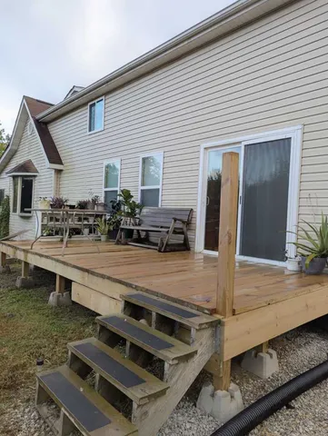 a view of a backyard with chairs and potted plants