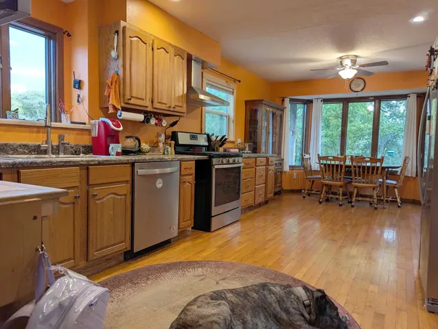a living room with furniture stove and kitchen view