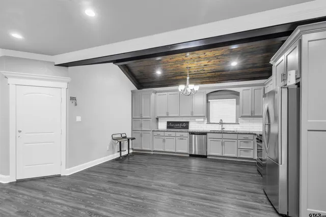 a kitchen with white cabinets and wooden floor
