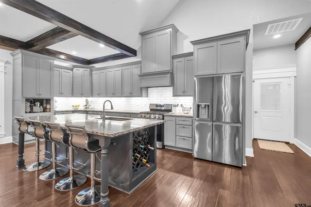 a kitchen with granite countertop stainless steel appliances a counter top space and cabinets