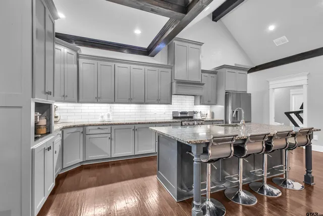 a kitchen with granite countertop stainless steel appliances lots of counter top space and a sink