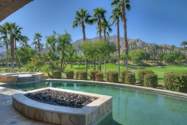 a view of a swimming pool with a patio and a lake view