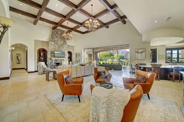 a living room with furniture a fireplace and a chandelier