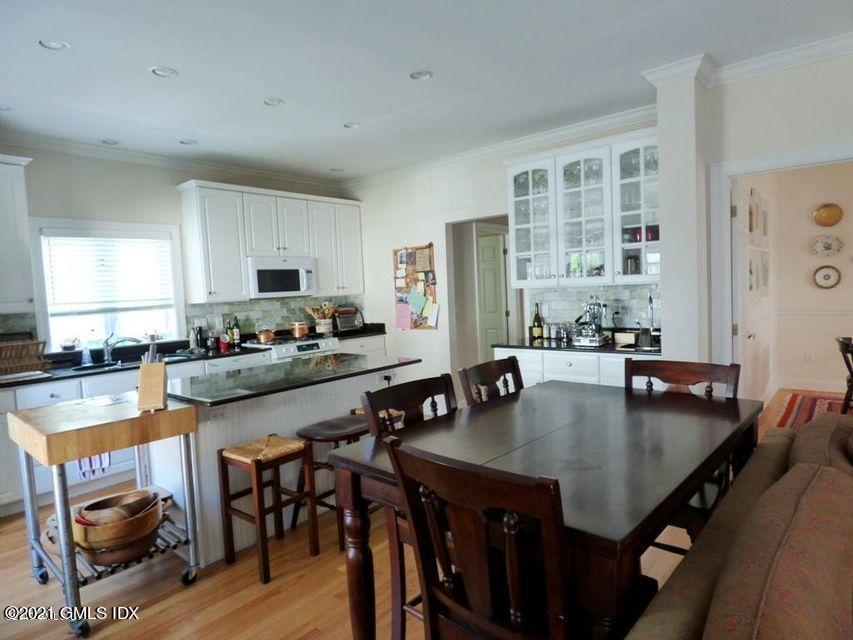 102 River Road Cos Cob, CT 06807 - Photo 8 of 14 a kitchen with granite countertop a table chairs microwave and cabinets