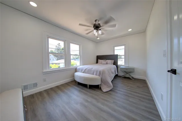 a bedroom with a bed ceiling fan and window