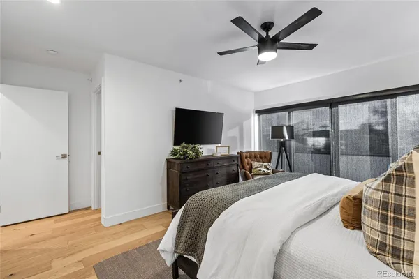 a bedroom with a bed a large window and flat screen tv