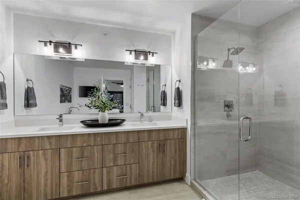 a bathroom with a double vanity sink mirror and shower