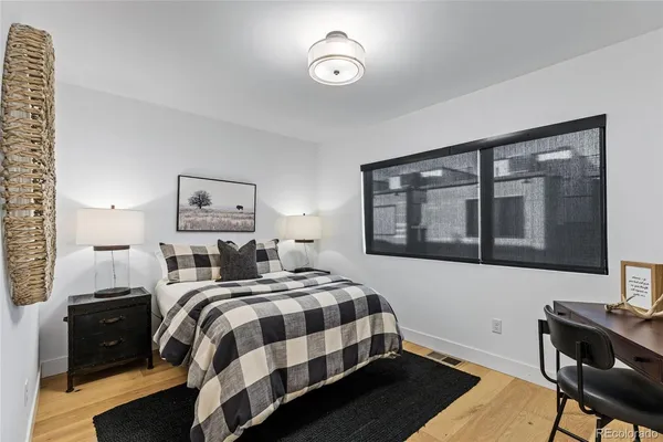 a bedroom with a bed and wooden floor