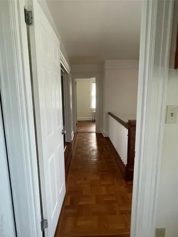 a view of a hallway with wooden floor and staircase