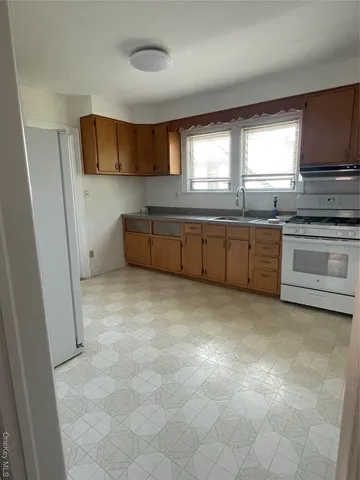 a view of a kitchen with a sink and a refrigerator