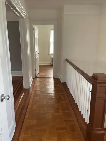 a view of a hallway with wooden floor and staircase