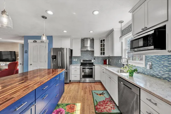 a kitchen with stainless steel appliances granite countertop a stove refrigerator and cabinets