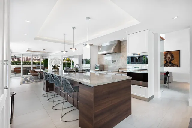 a kitchen with stainless steel appliances kitchen island granite countertop a table and chairs in it
