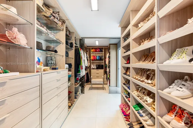 a view of walk in closet with clothes and shoes