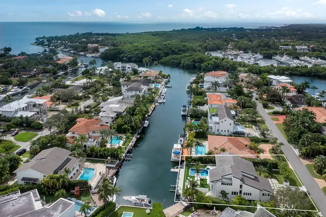 an aerial view of a city with lots of residential buildings ocean and mountain view in back
