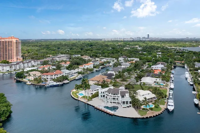 an aerial view of a city with lots of residential buildings ocean and mountain view in back