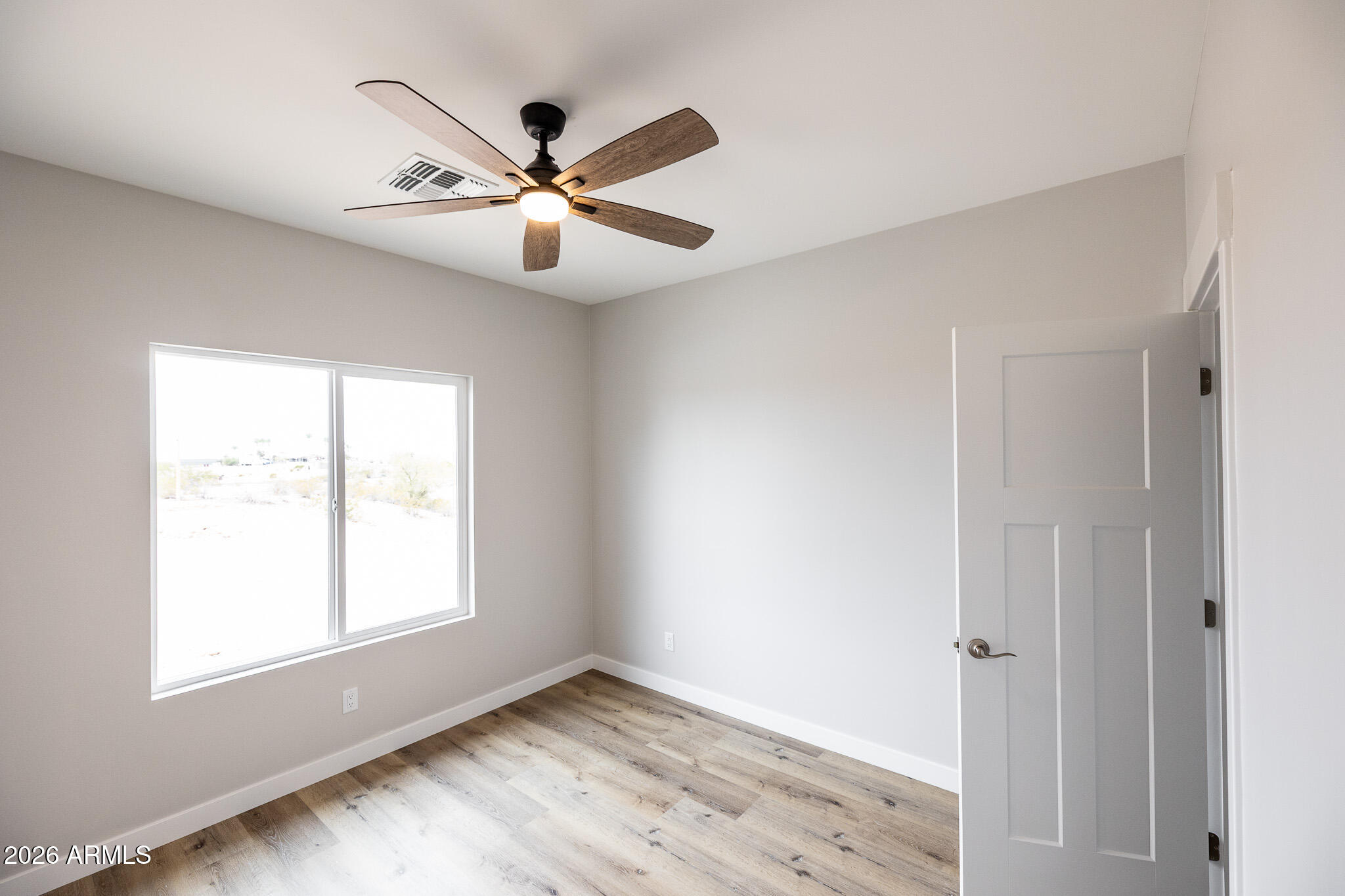 11459 East Adamsville Road Florence, AZ 85132 - Photo 24 of 63 a view of an empty room with wooden floor and a window