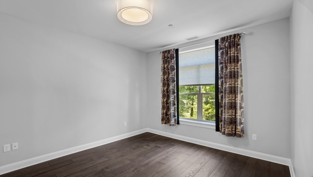 635 Old Post Road, Unit 204 Sharon, MA 02067 - Photo 11 of 22 an empty room with wooden floor and windows