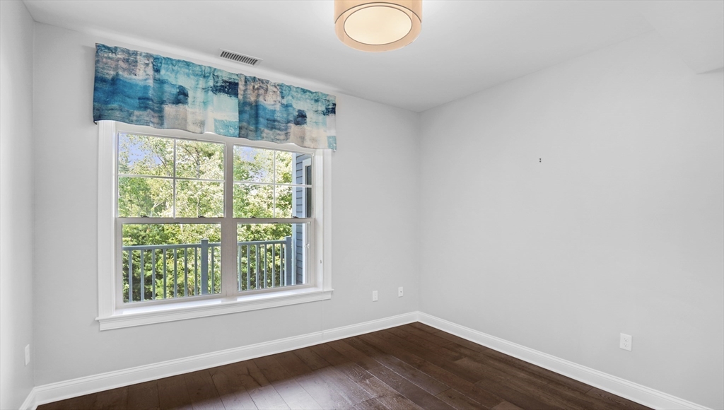 635 Old Post Road, Unit 204 Sharon, MA 02067 - Photo 13 of 22 an empty room with wooden floor and windows