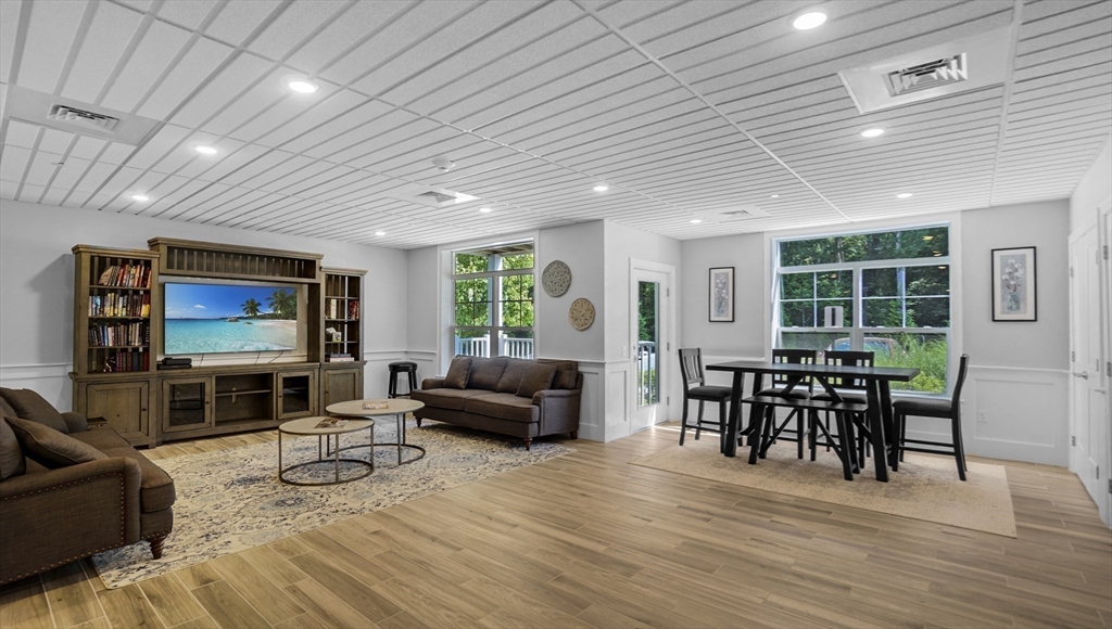 635 Old Post Road, Unit 204 Sharon, MA 02067 - Photo 18 of 22 a living room with furniture flat screen tv and wooden floor