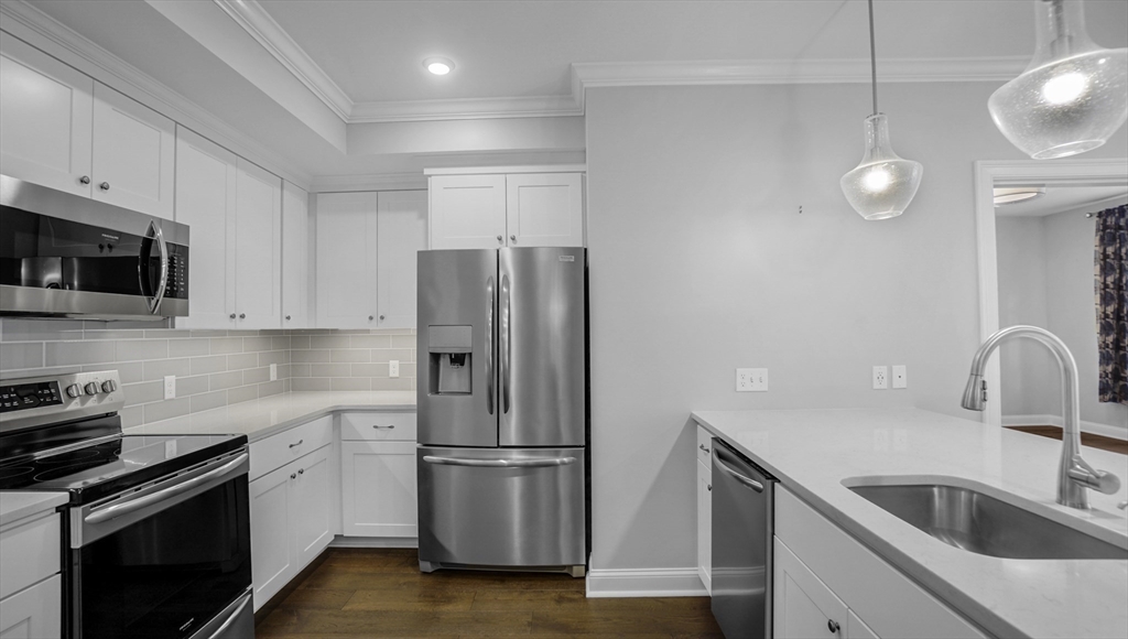 635 Old Post Road, Unit 204 Sharon, MA 02067 - Photo 4 of 22 a kitchen with a refrigerator sink and white cabinets