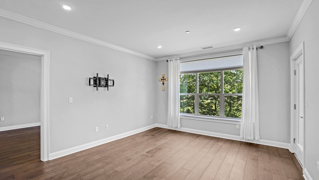 635 Old Post Road, Unit 204 Sharon, MA 02067 - Photo 6 of 22 a view of an empty room with wooden floor and a window