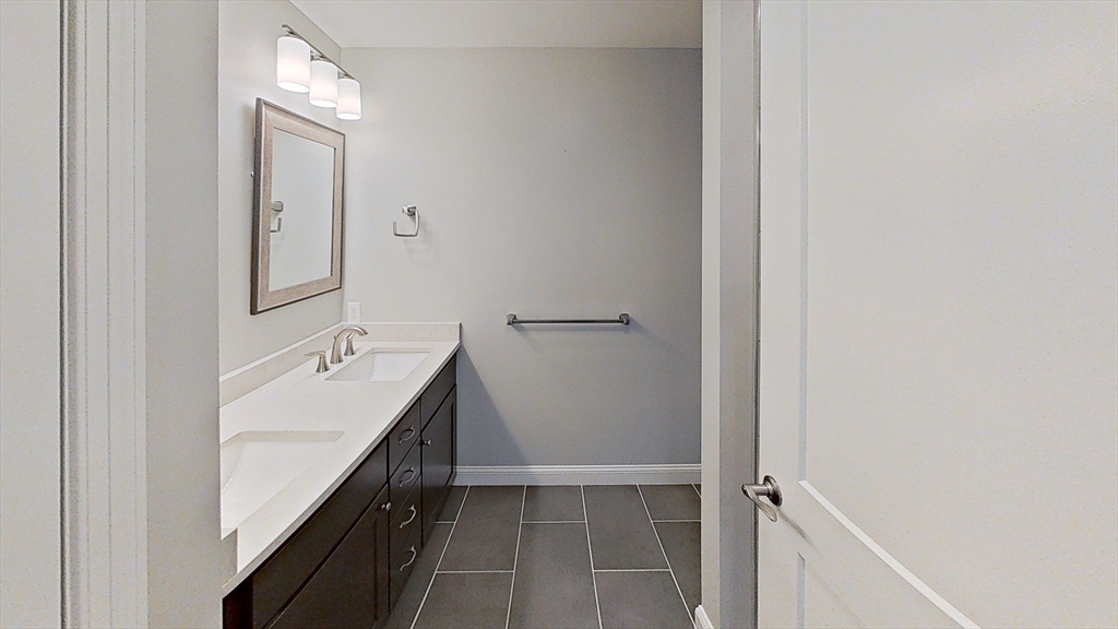 635 Old Post Road, Unit 204 Sharon, MA 02067 - Photo 8 of 22 a bathroom with a double vanity sink and mirror