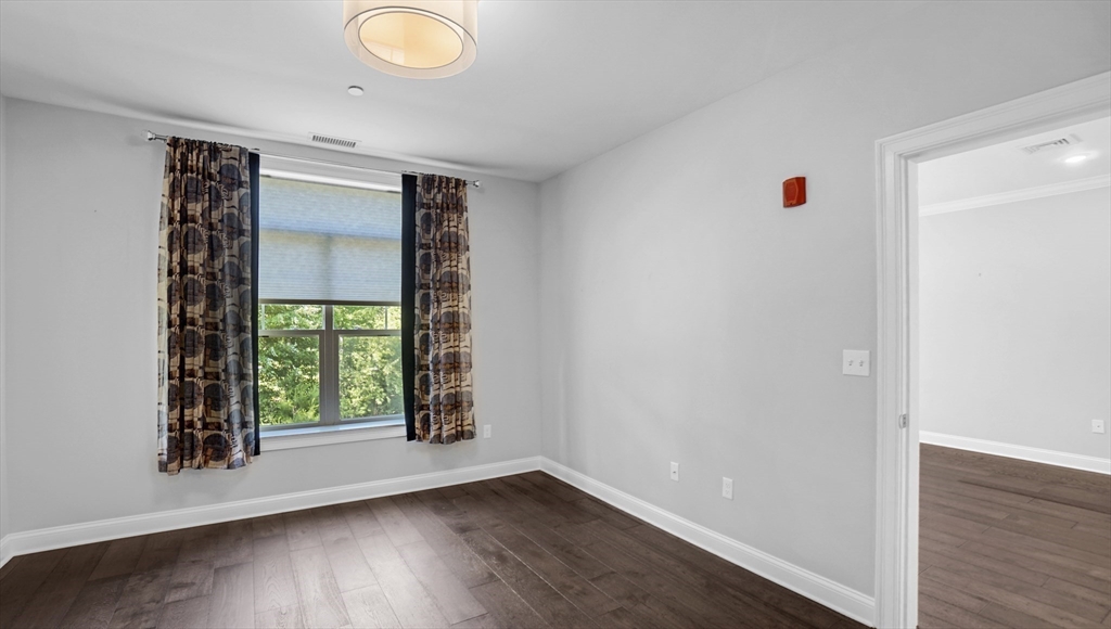635 Old Post Road, Unit 204 Sharon, MA 02067 - Photo 10 of 22 an empty room with wooden floor and windows