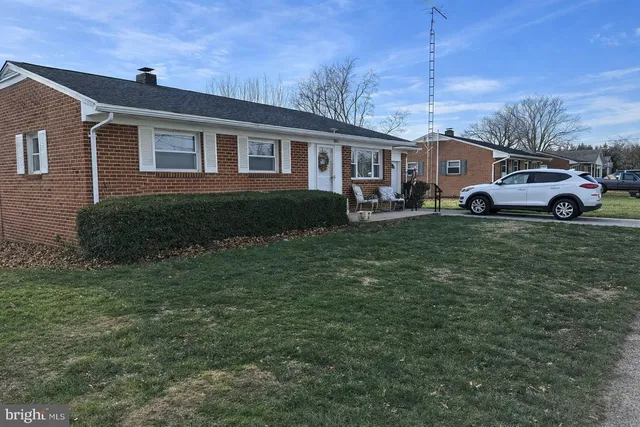 a view of a yard in front of a house with large windows