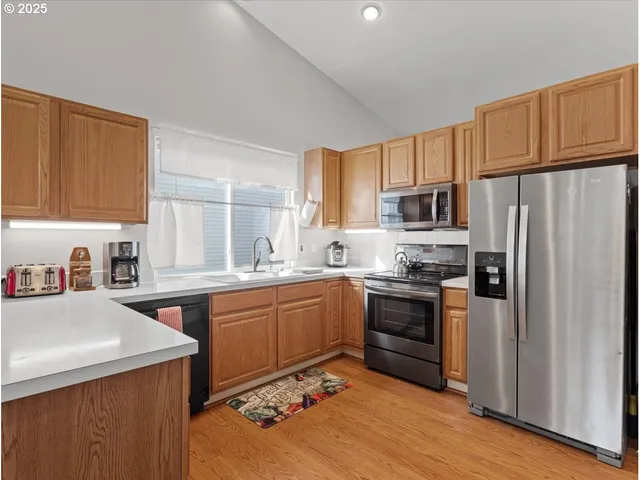 a kitchen with stainless steel appliances granite countertop a refrigerator stove microwave and sink
