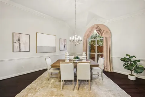 a dining room with wooden floor and a potted plant