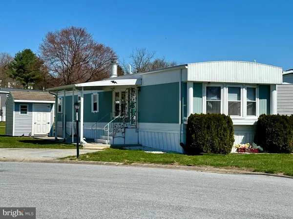 a view of a house with a yard and large tree
