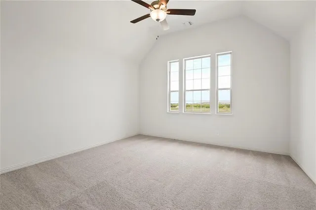 an empty room with a window and ceiling fan