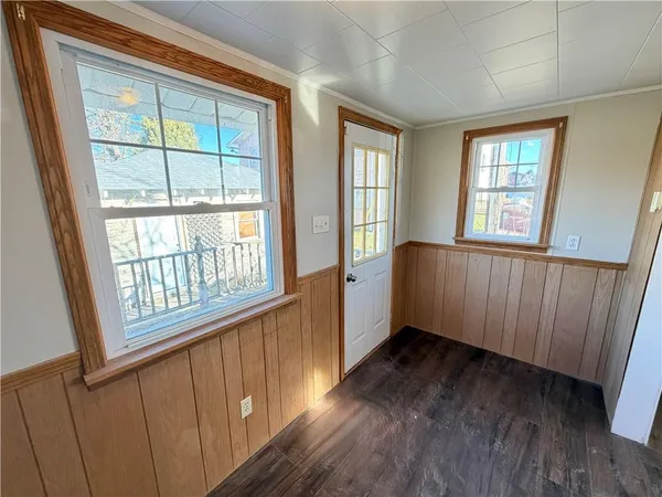 a view of an empty room with wooden floor and windows