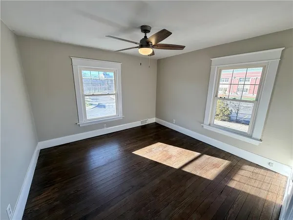 a view of wooden floor in an empty room with a window
